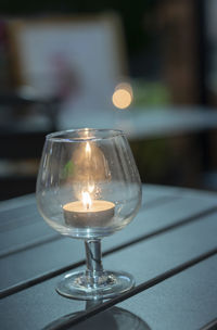 Close-up of illuminated light bulb on table in restaurant