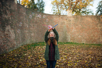 Happy young woman standing at park