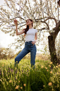 Full length of young woman exercising on field