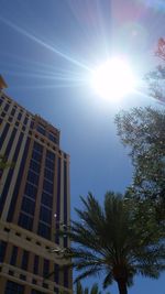 Low angle view of buildings against blue sky on sunny day