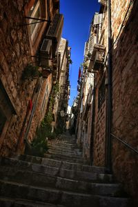 Low angle view of alley amidst buildings in town