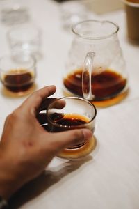 Midsection of person holding coffee cup on table