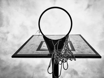 Low angle view of basketball hoop against cloudy sky