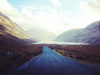 Road amidst mountains against sky