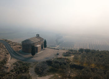 High angle view of chapel on mountain against hazy sky
