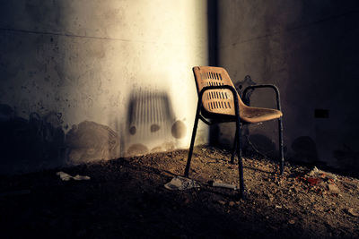 Empty chairs against wall in abandoned building