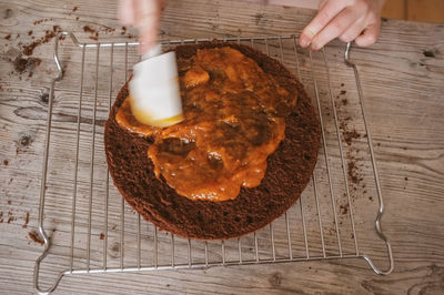 Cropped image of hand spreading preserved on cake
