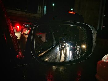 Reflection of illuminated street in city during rainy season