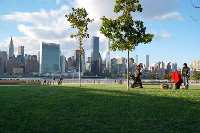 People in park by city against sky