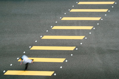 High angle view of yellow crossing sign on road