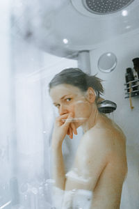 Portrait of shirtless woman in bathroom