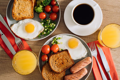 English breakfast with cup of black coffee and orange juice, grilled sausage and whole wheat toast