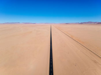 Scenic view of desert against clear blue sky