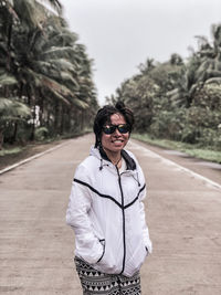 Portrait of man wearing sunglasses standing on road