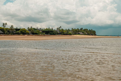 Scenic view of a beach against resort amidst palm trees at manda island in lamu archipelago, kenya