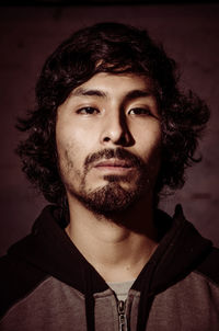 Close-up portrait of young man against gray background