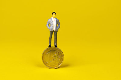 A figurine hovering over a 1 euro coin