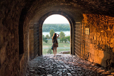 Rear view of woman standing against wall