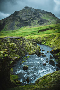 Scenic view of stream and mountain against sky