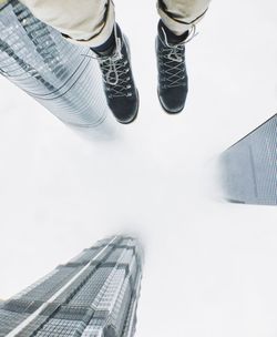 Low section of people on building against sky