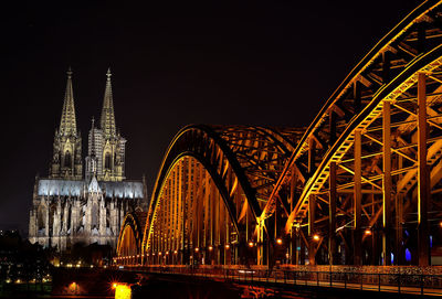 Low angle view of illuminated bridge against sky at night