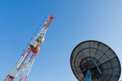 Low angle view of communications tower against clear blue sky