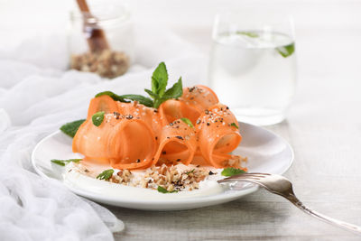 Gluten free vegetarian salad with carrot and yogurt seasoned with crushed nuts and spices, mint