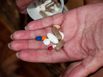 Close-up of woman showing pills on hand