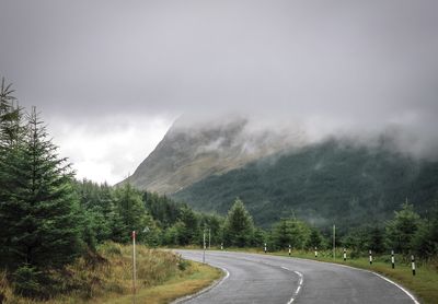 Road by trees against sky