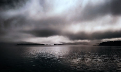 Scenic view of sea against storm clouds