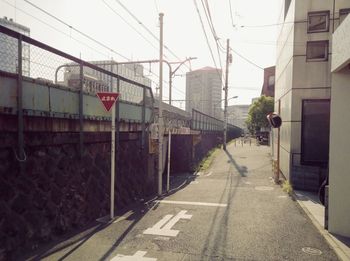 Road amidst buildings in city against clear sky