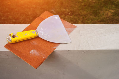 Construction stainless steel trowel tools and sandpaper on cement mortar wall