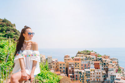 Young woman by sunglasses on sea against sky