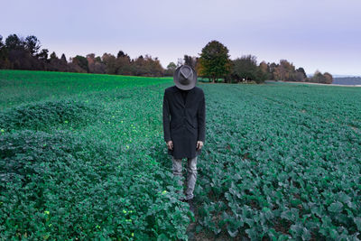 Man standing on field against sky