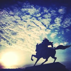 Low angle view of silhouette statue against sky during sunset