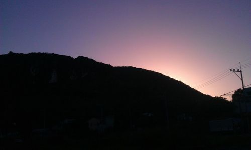 Scenic view of silhouette mountains against clear sky at sunset