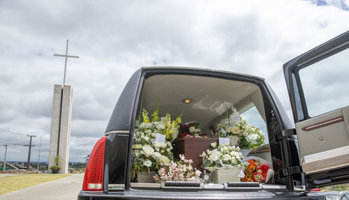 Closeup shot of a funeral casket or coffin in a hearse or chapel or burial at cemetery
