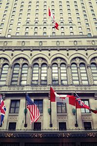 Low angle view of flag against building in city