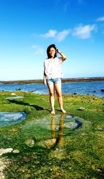 Full length of man standing in sea against sky