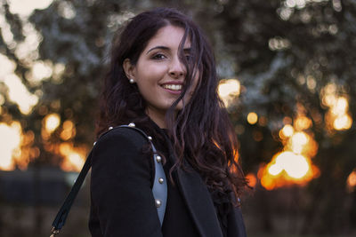 Side view portrait of smiling young woman during sunset