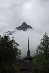 View of temple against cloudy sky and mountain 