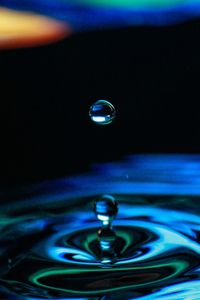 Macro shot of drop falling on water