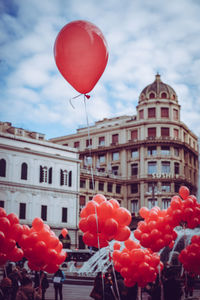 Red balloons against buildings in city