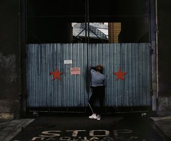 Rear view of woman standing on wall