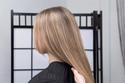 Cropped hand of hairdresser holding woman hair at salon