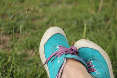 Low section of woman relaxing on grass in park