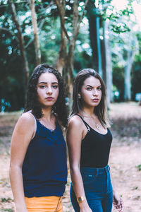 Portrait of friends standing against trees