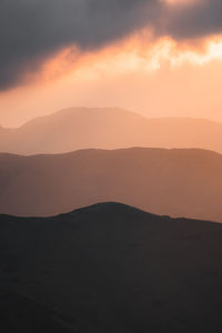 Scenic view of silhouette mountains against sky during sunset