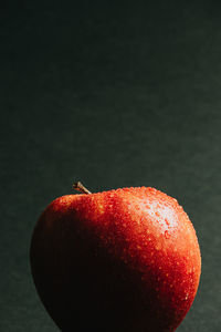 Close-up of apple on table against black background