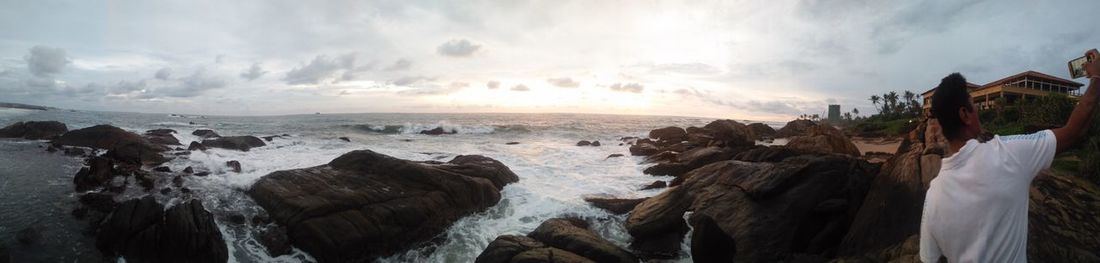 Panoramic shot of rocks on beach against sky